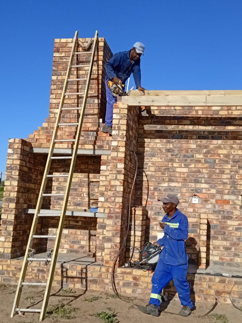 Bricklayers framing a roof structure